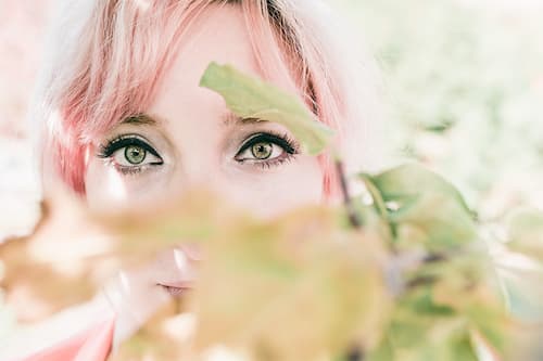Women behind a Bush Closeup of women's Eyes behind a plant