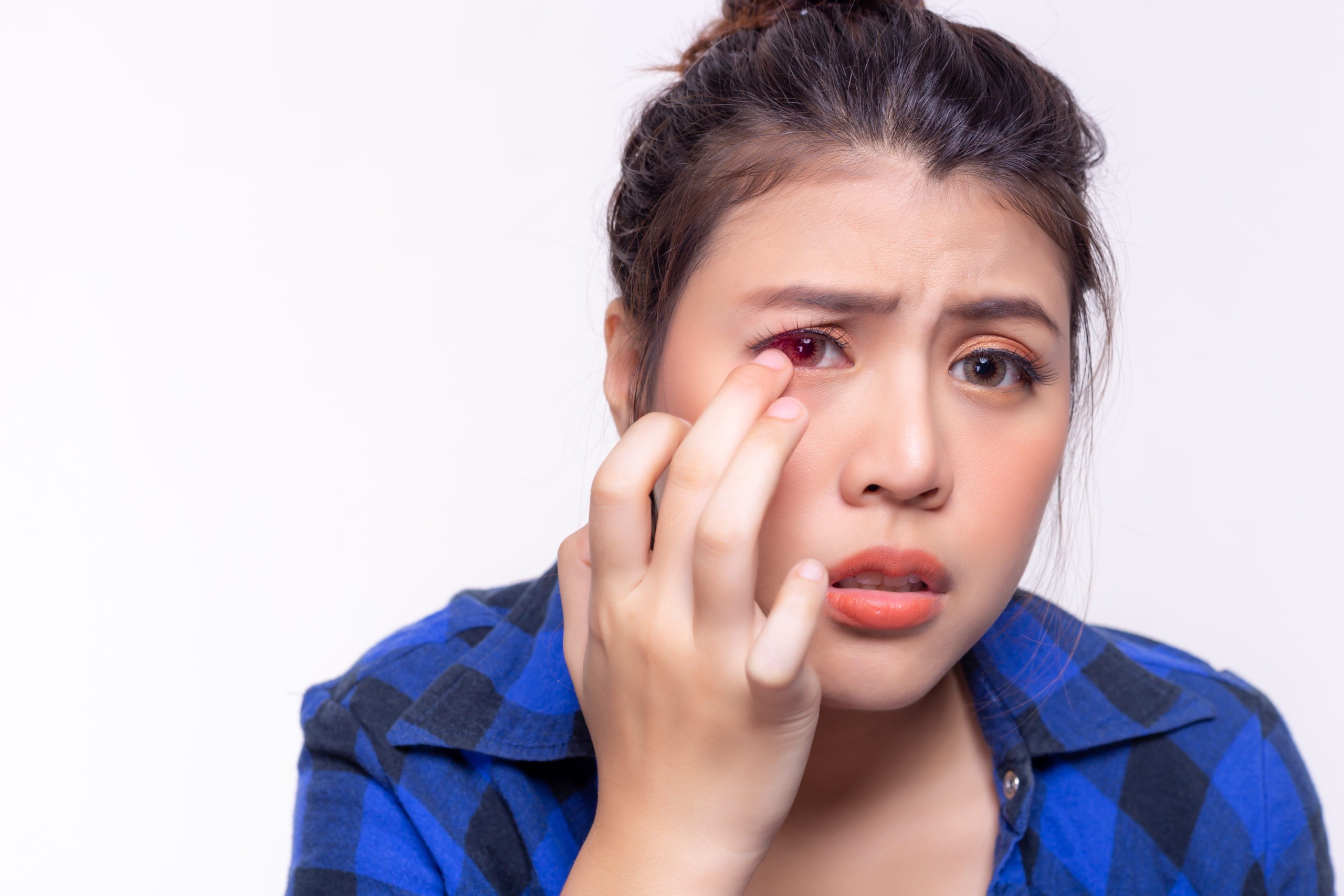 women touching her eye looking concerned