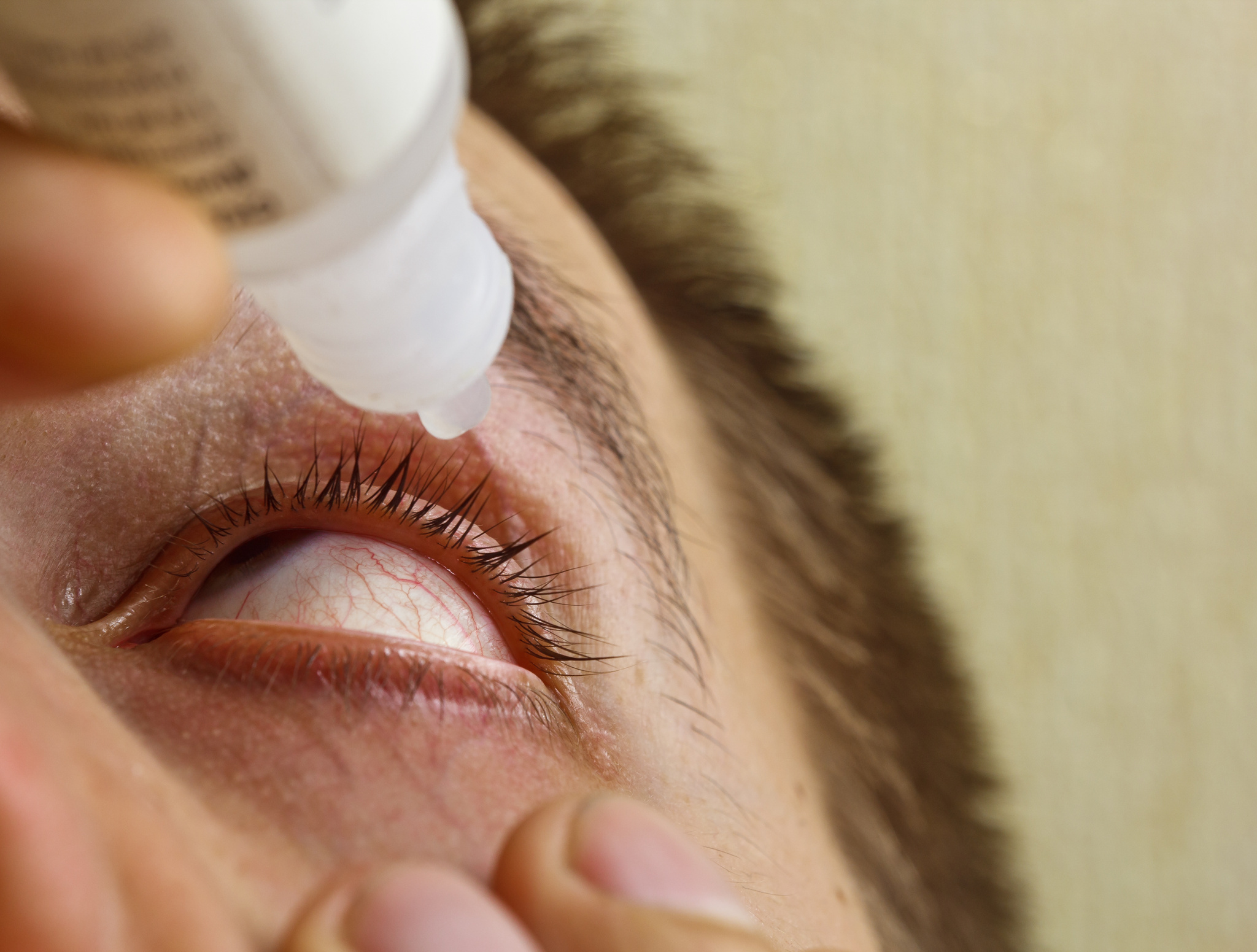 man putting presbyopia eye drops in his eye