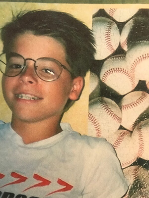 Photo Reference picture of boy wearing glasses with baseballs in the background