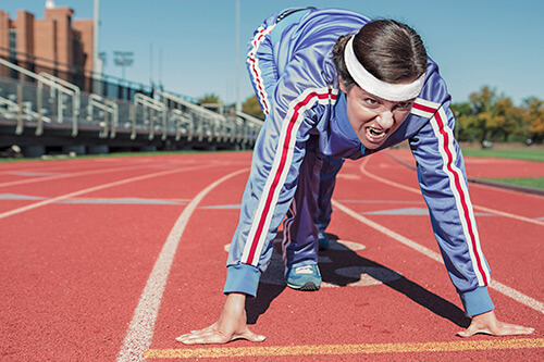Runner at the Starting Line women in blue track suit starting position on a running track
