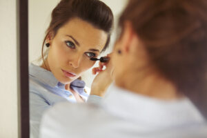 Lady with LASIK putting on makeup in the mirror